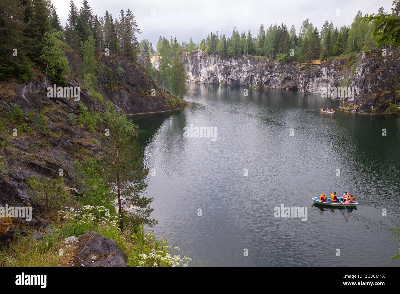 Ruskeala, Russie - 12 juin 2021 : paysage de Karelian avec des touristes dans un bateau naviguant à travers une ancienne carrière de marbre remplie d'eau souterraine Banque D'Images