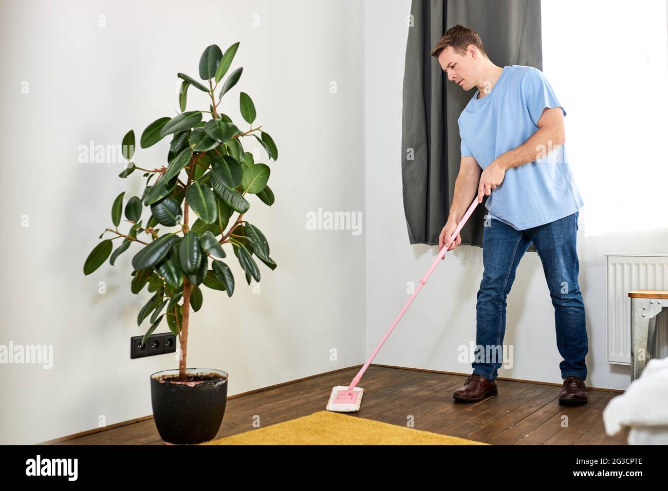 Jeune femme de ménage nettoyage de plancher tenant la mop dans le plancher  de la maison de salon aidant sa femme, en enlevant la saleté et la  poussière, à la maison Photo