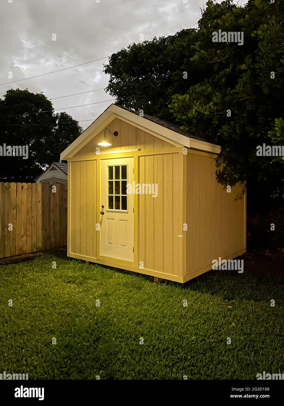 L'outil de jardin a été jeté à l'extérieur dans une cour pendant la nuit. De nombreux arbres entourent le hangar. Projet DIY Banque D'Images