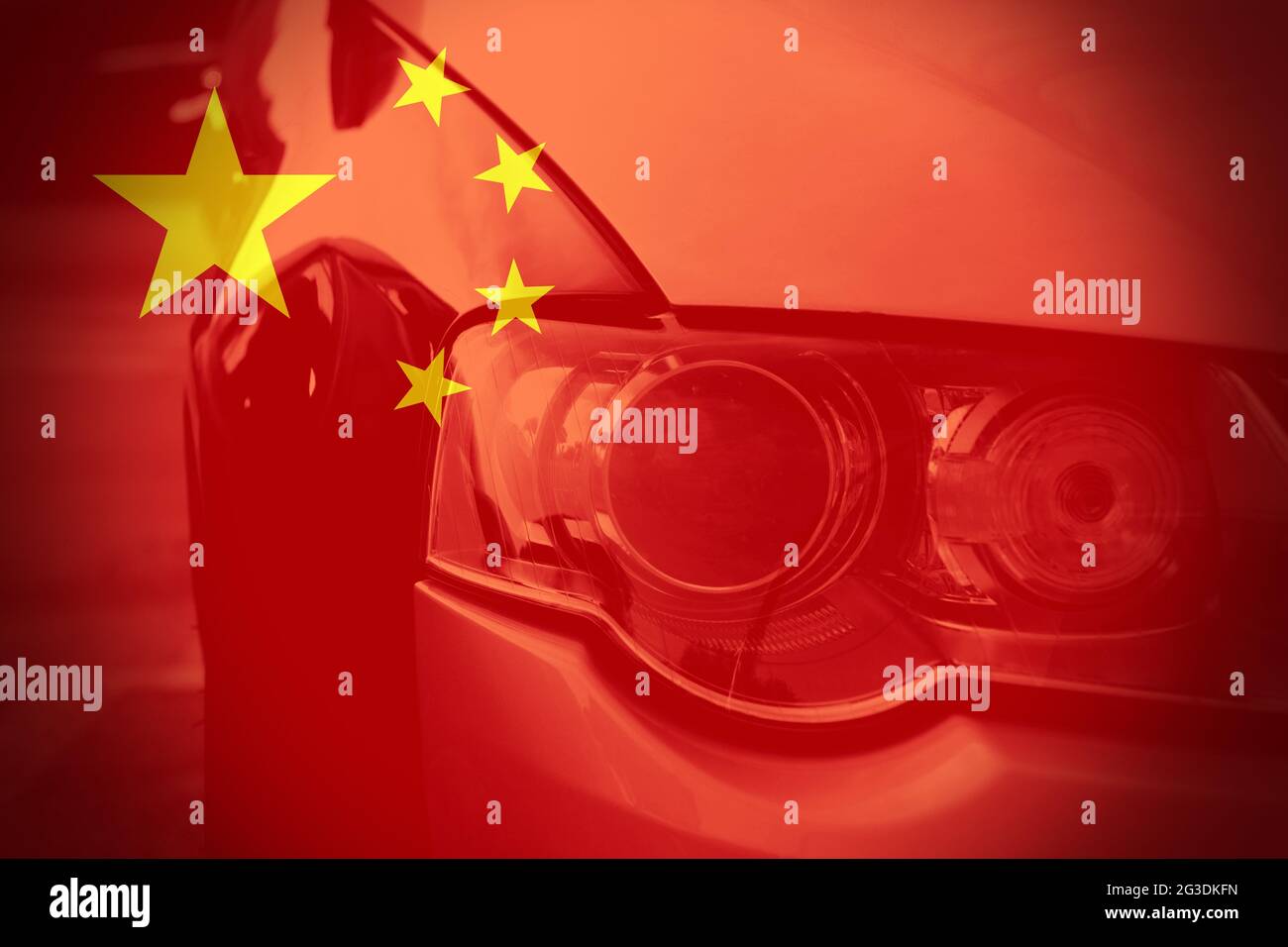 Vue rapprochée d'un phare de voiture avec le drapeau chinois comme arrière-plan. Concept de voitures en Chine ou dans l'industrie automobile chinoise. Banque D'Images