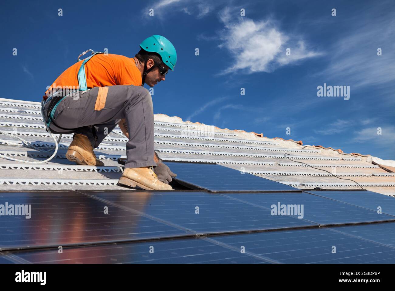 un technicien installe des panneaux solaires photovoltaïques de nouvelle génération sur le toit Banque D'Images