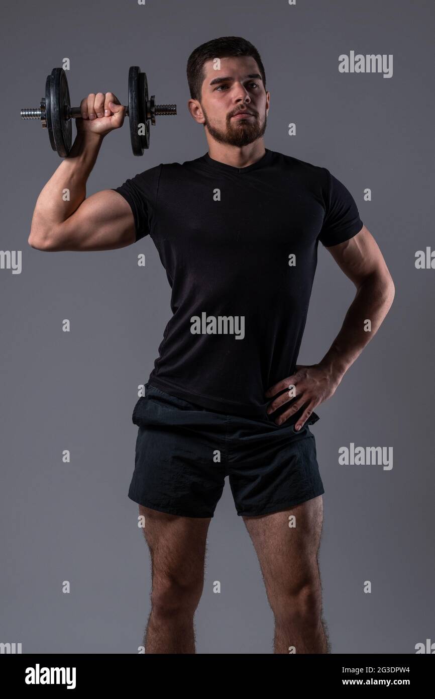 Jeune homme sportif faisant un haltère de bras une presse d'épaule Photo  Stock - Alamy