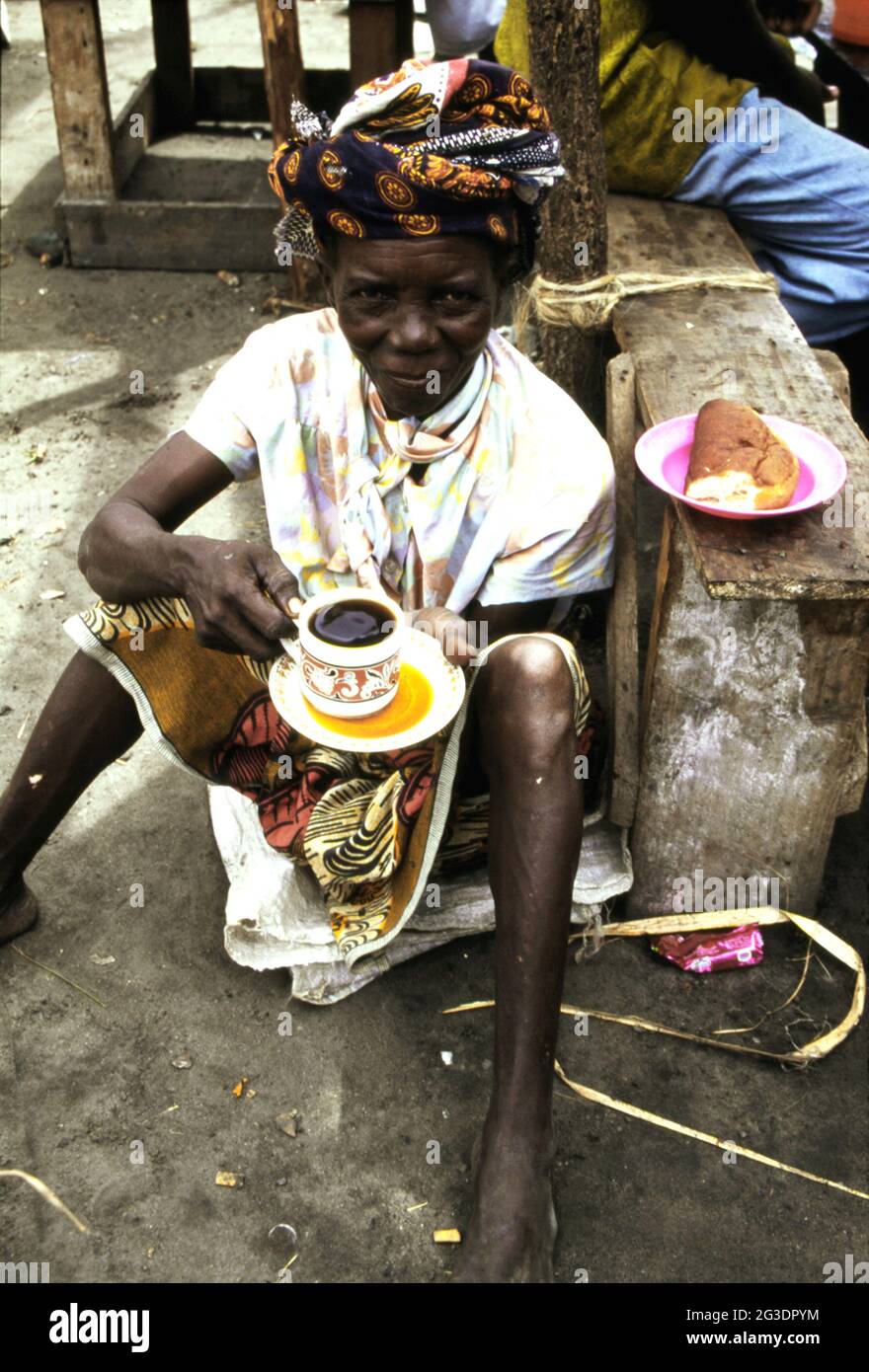 Femme africaine appréciant une tasse de thé très noir à Dar es-Salaam, Tanzanie Banque D'Images