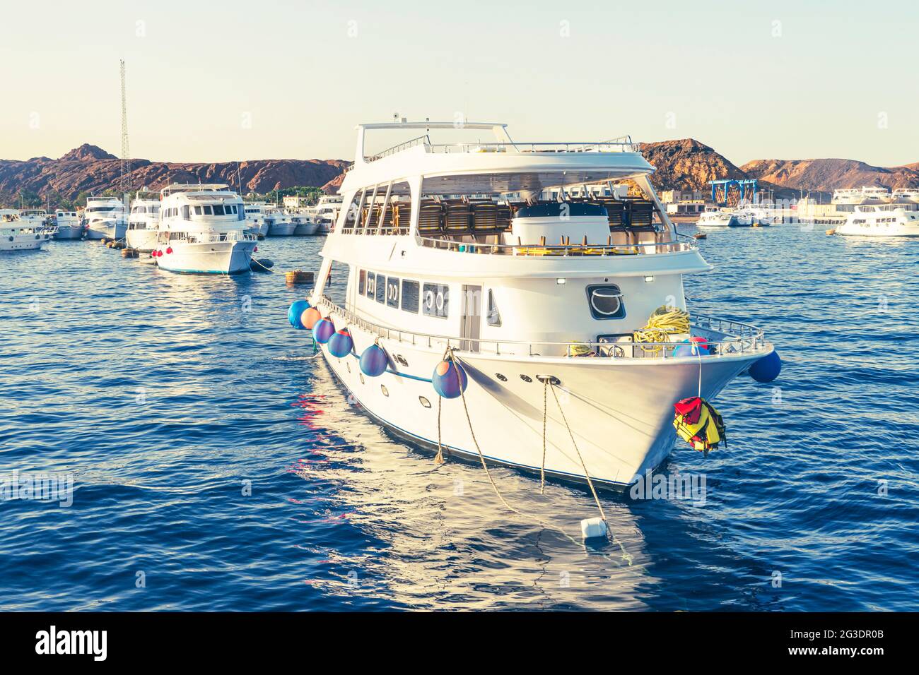 de nombreux yachts blancs dans le port maritime avec la toile de fond de hautes montagnes et de rochers. Banque D'Images