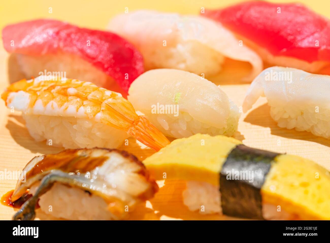 Gros plan sur des morceaux de sushis ou de riz nigirizushi pressés à la main avec divers fruits de mer dont des congridae japonais anago, des œufs grillés au tamagoyaki ou des crevettes Banque D'Images