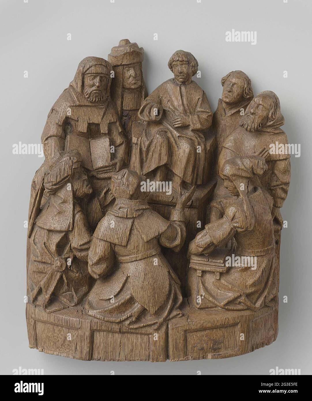 Jésus entre les scribes. Jésus, en tant que garçon, est sur une élévation, entouré par des auditeurs. De chaque côté deux et en face de lui sur une banque légèrement inférieure trois auditeurs. Jésus tient la main gauche pour les moyens et le bras droit plié et légèrement vers l'avant. Certains auditeurs qui font des gestes avec leurs mains, deux autres tiennent un livre bourré sur ses genoux. Le Christ porte une tunique, les Pharisiens sont vêtus de robes diverses et avec un glamour, un turban ou un chapeau. Le BNK, sur lequel sont assis les trois choses, expose des panneaux approfondis. L'homme dans la tuyauterie avec la cagoule, complètement à droite, peut imaginer Joseph. Banque D'Images