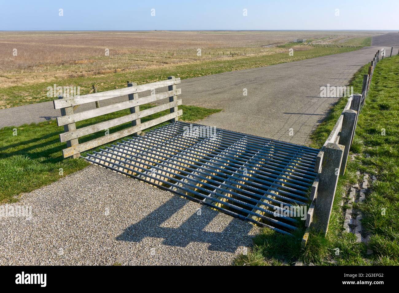 Grille de bétail ou garde de bétail pour empêcher le bétail de passer le long d'une route qui pénètre l'escrime entourant un morceau de terre clos. Banque D'Images