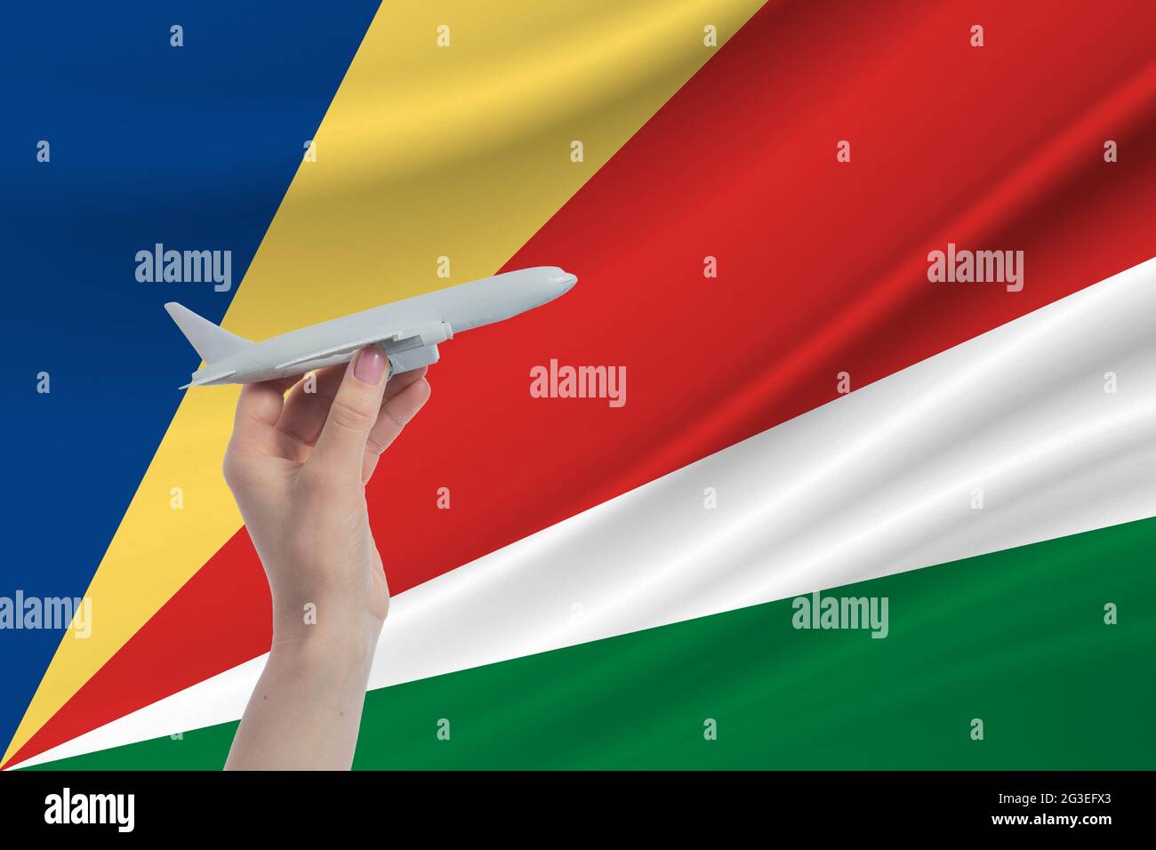 Avion en main avec le drapeau national des Seychelles. Voyage aux Seychelles. Banque D'Images