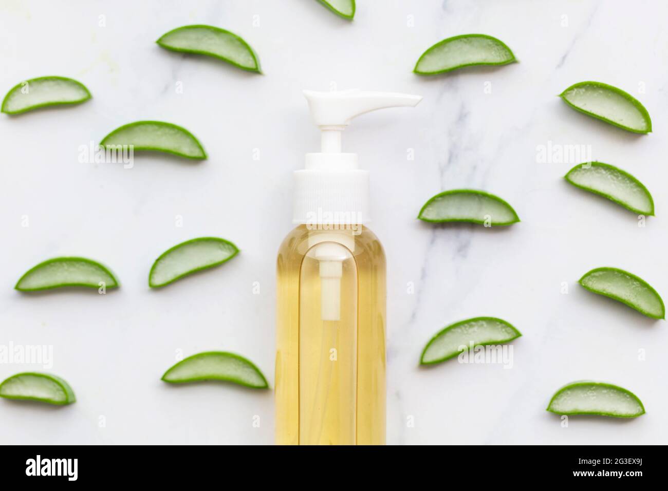 Tranches de vera d'aloès naturel autour d'une bouteille de produit cosmétique Banque D'Images