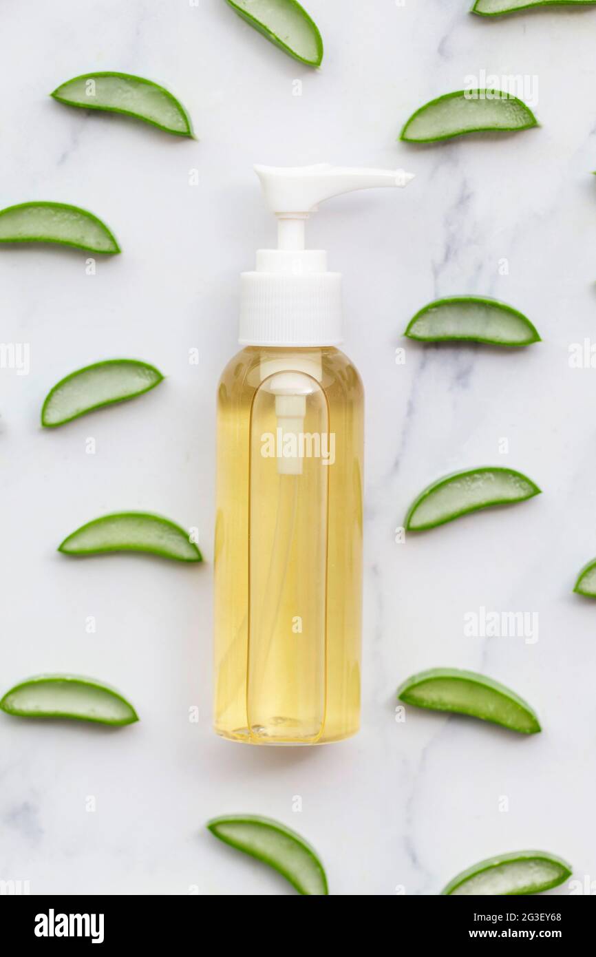 Tranches de vera d'aloès naturel autour d'une bouteille de produit cosmétique Banque D'Images
