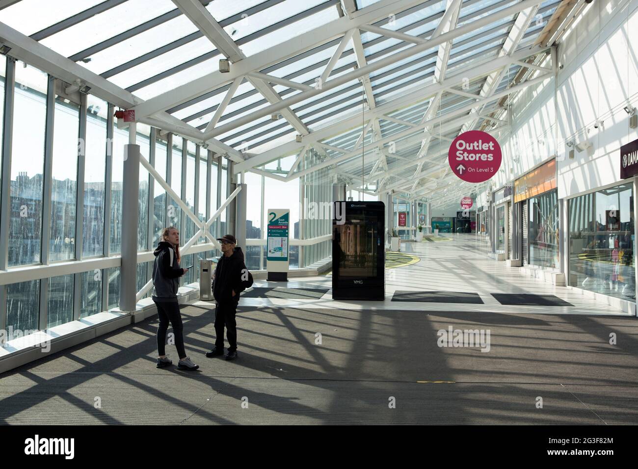 Deux personnes dans le centre commercial de Princes Quay, maintenant déserté, vide et fermé, dans le centre de Hull City, tandis que l'épidémie de coronavirus s'aggrave aux États-Unis Banque D'Images
