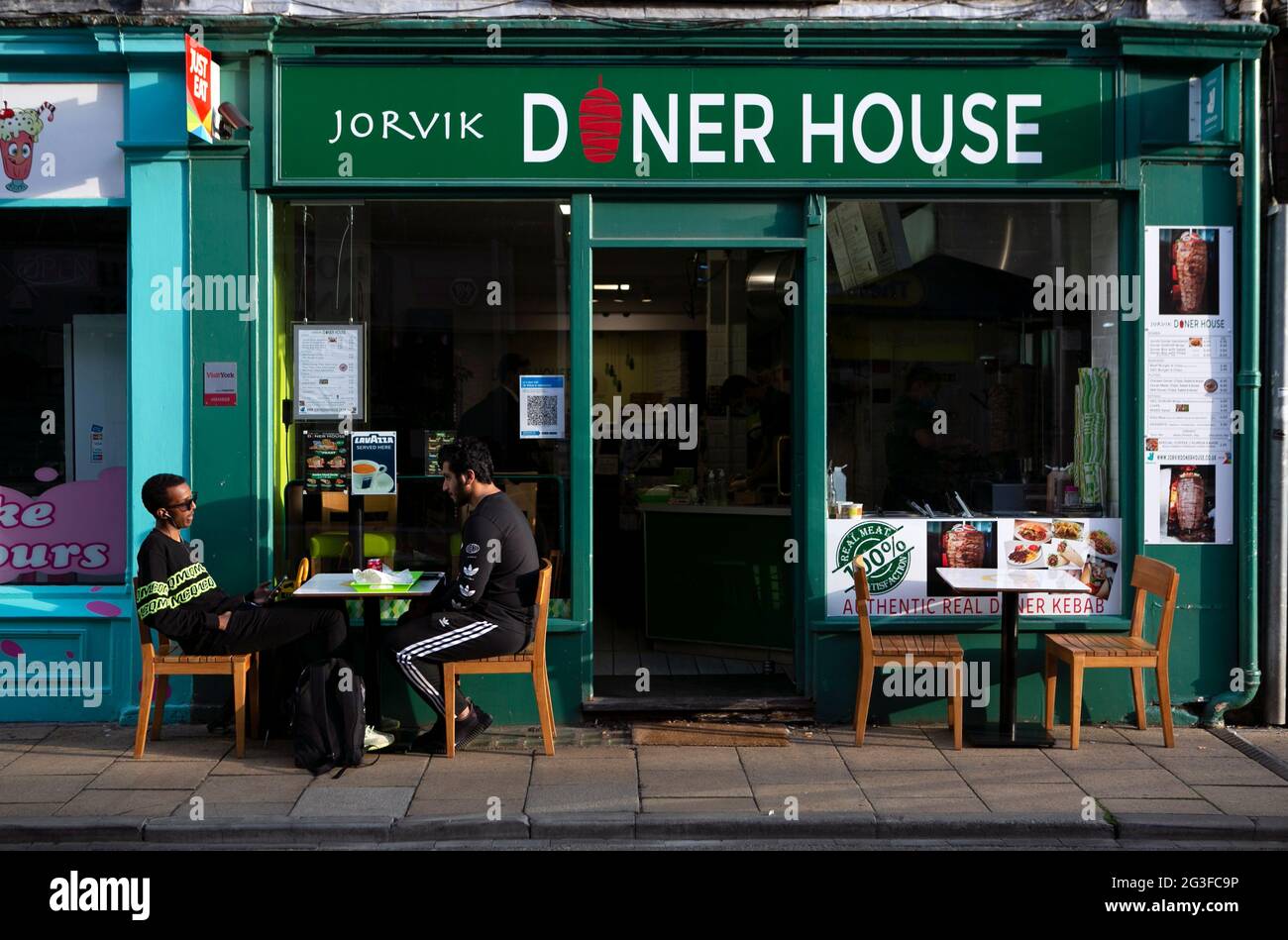 Personnes assises sur des tables entourées de tables vides dans le centre-ville de York dans le nord du Yorkshire. À la fin du mois d’août, le gouvernement a « Eat Out to H » Banque D'Images