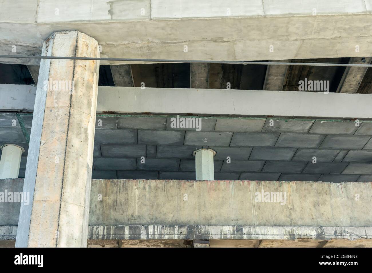 Structure en béton armé de la voie de passage d'autoroute. Fissures des poutres en béton sous le pont. Vue de bas en bas. Banque D'Images