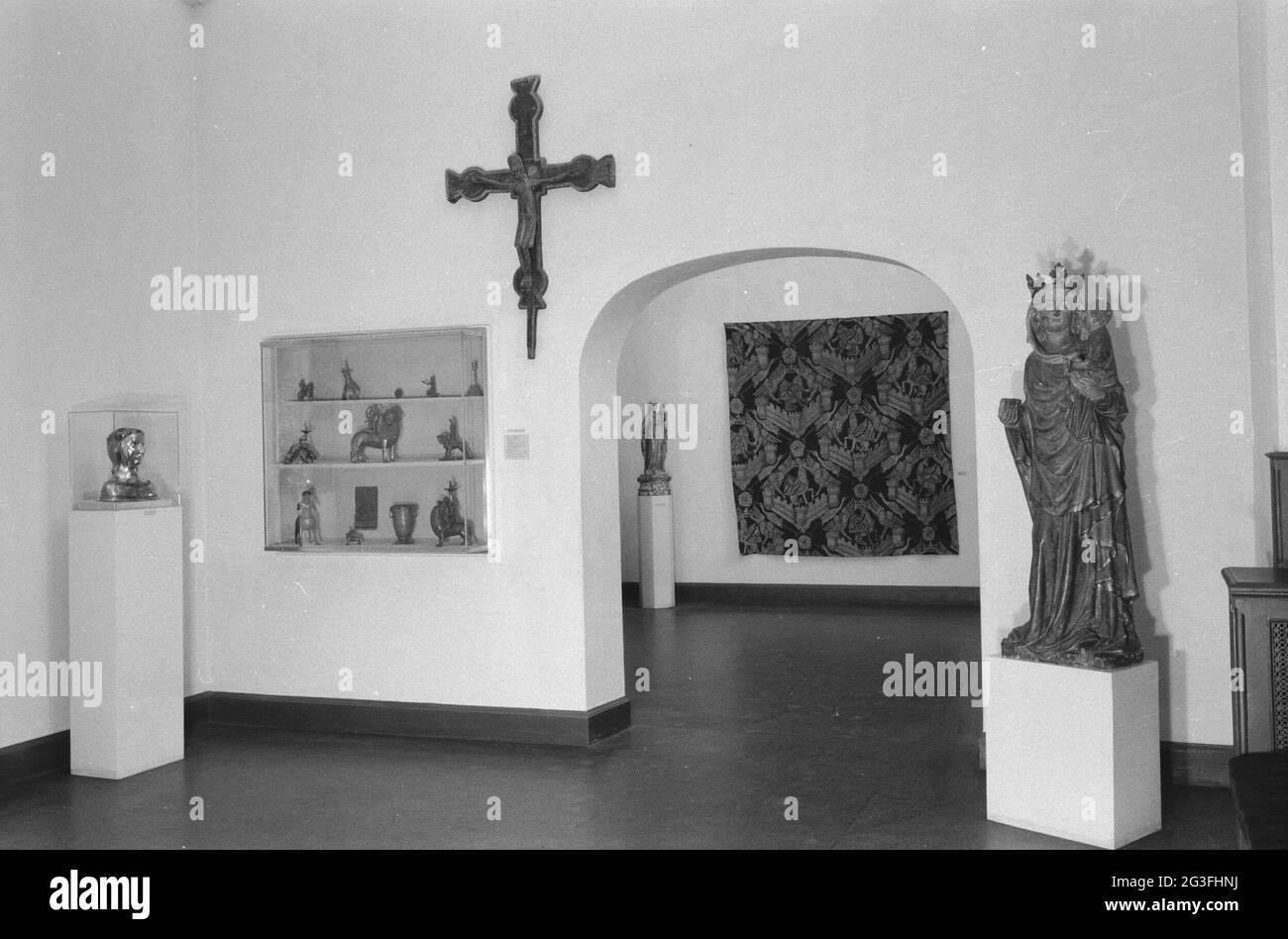 Salle avec divers objets, y compris des images dans des vitrines et sur des socles, un crucifix et un passage; Interiors West, installé au début des années 1950. . Banque D'Images