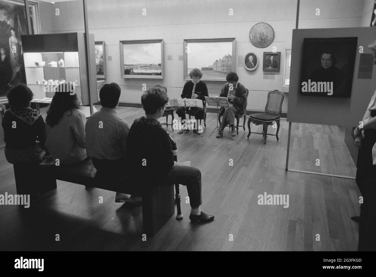 Deux personnes assises jouent des instruments pour regarder le public ; week-end musique. . Banque D'Images