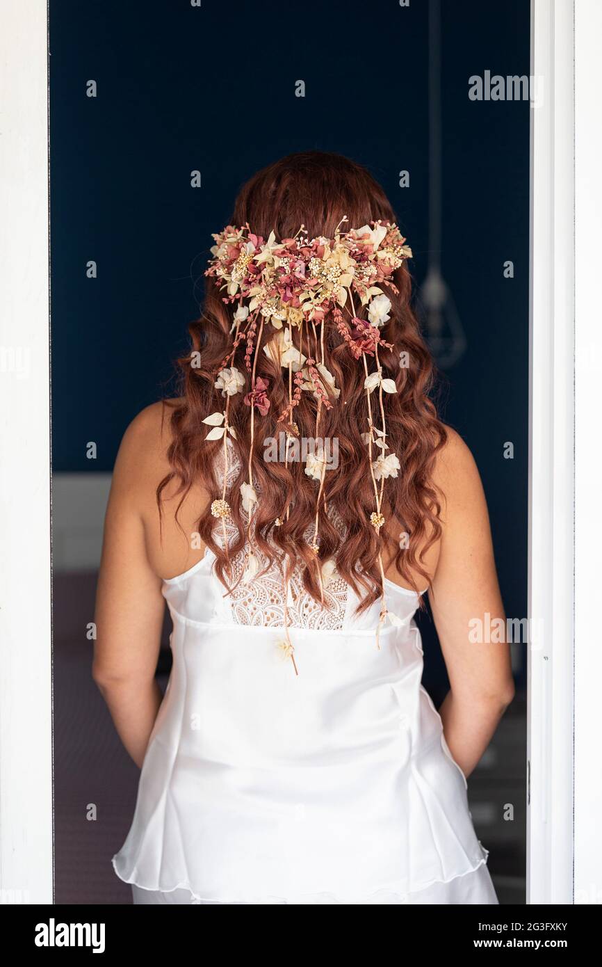 Vue arrière de la coiffure de boho d'une mariée, tête de fleur, mise au point douce Banque D'Images