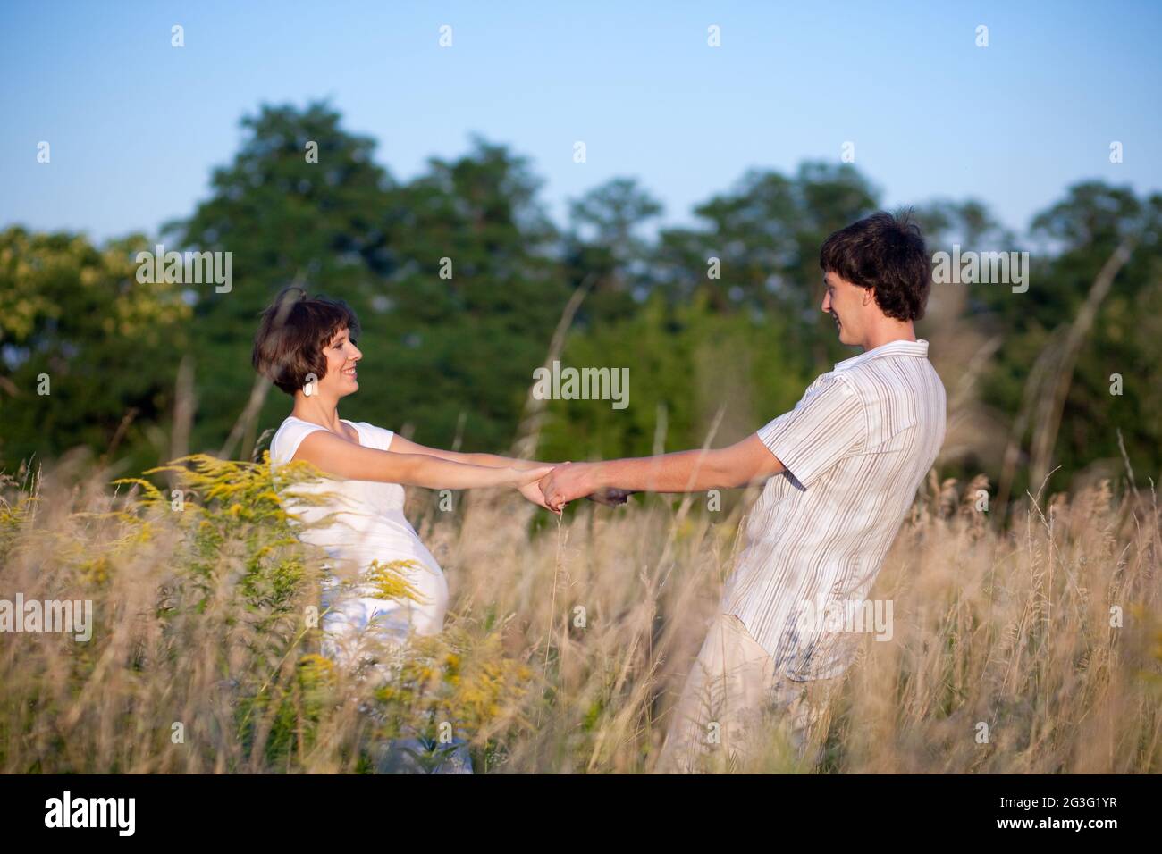 Danse enceinte dans le parc avec le mari Banque D'Images