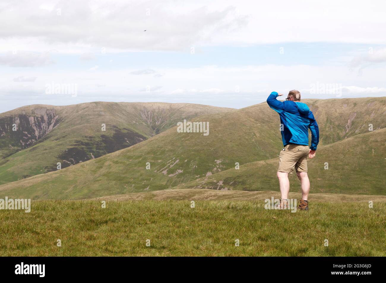 Un homme donne sur Arant Haw dans le parc national de Yorkshire Dales. Il regarde vers les collines voisines. Banque D'Images