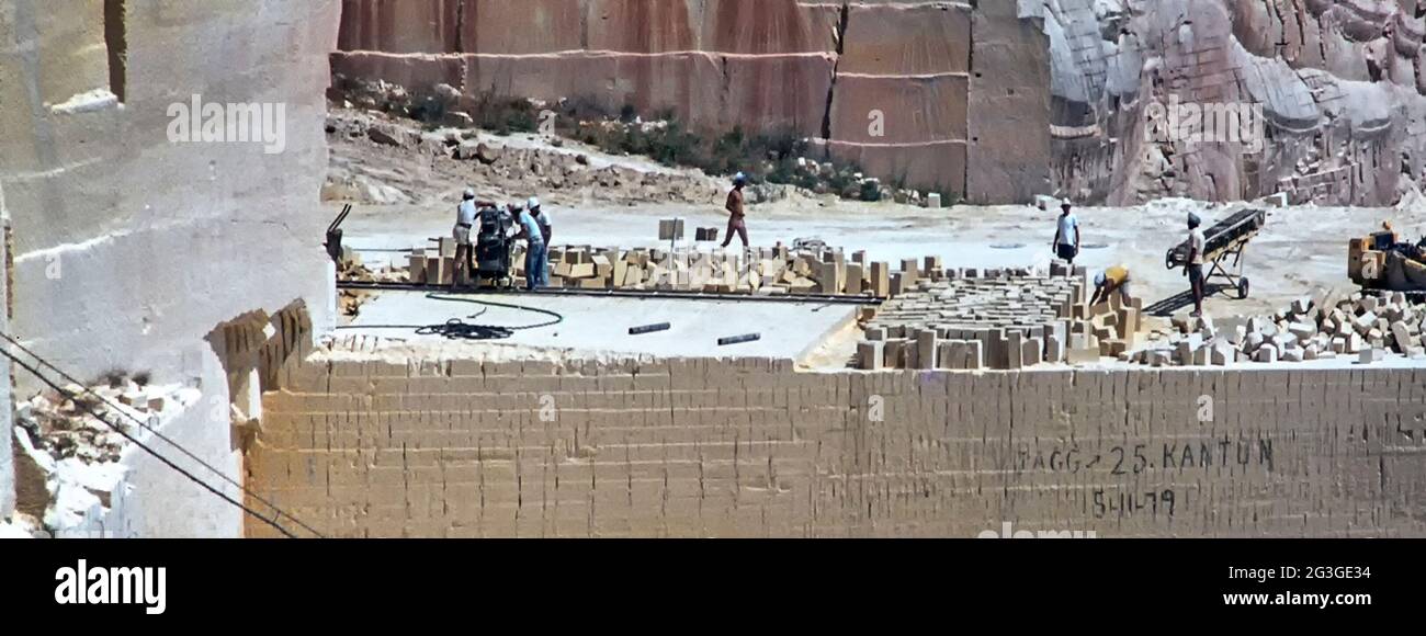 Vue des archives des années 1980 des travailleurs maltais de la mine de surface travaillant au-dessus de la chute de cisaillement de la face non protégée de la fonte calcaire ouverte carrière avec des problèmes de santé et de sécurité après des années d'utilisation de la scie à disque et de scier dans la roche molle à Être découpés en blocs pour les chantiers de construction des années 80 sur l'île de Malte dans l'image historique d'archives juin 1981 Banque D'Images