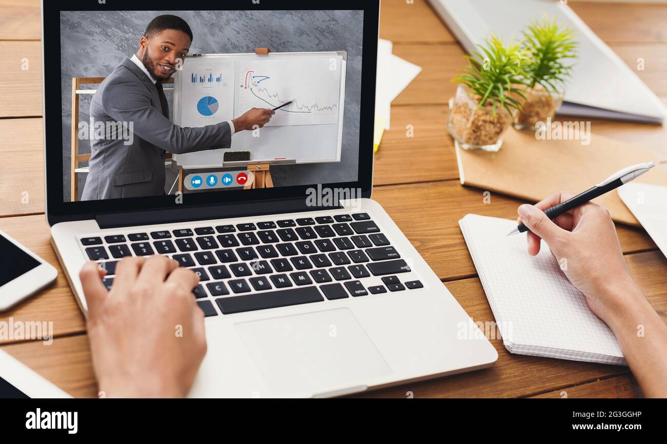 Femme d'affaires ayant une réunion en ligne avec un homme d'affaires via un ordinateur portable au bureau Banque D'Images