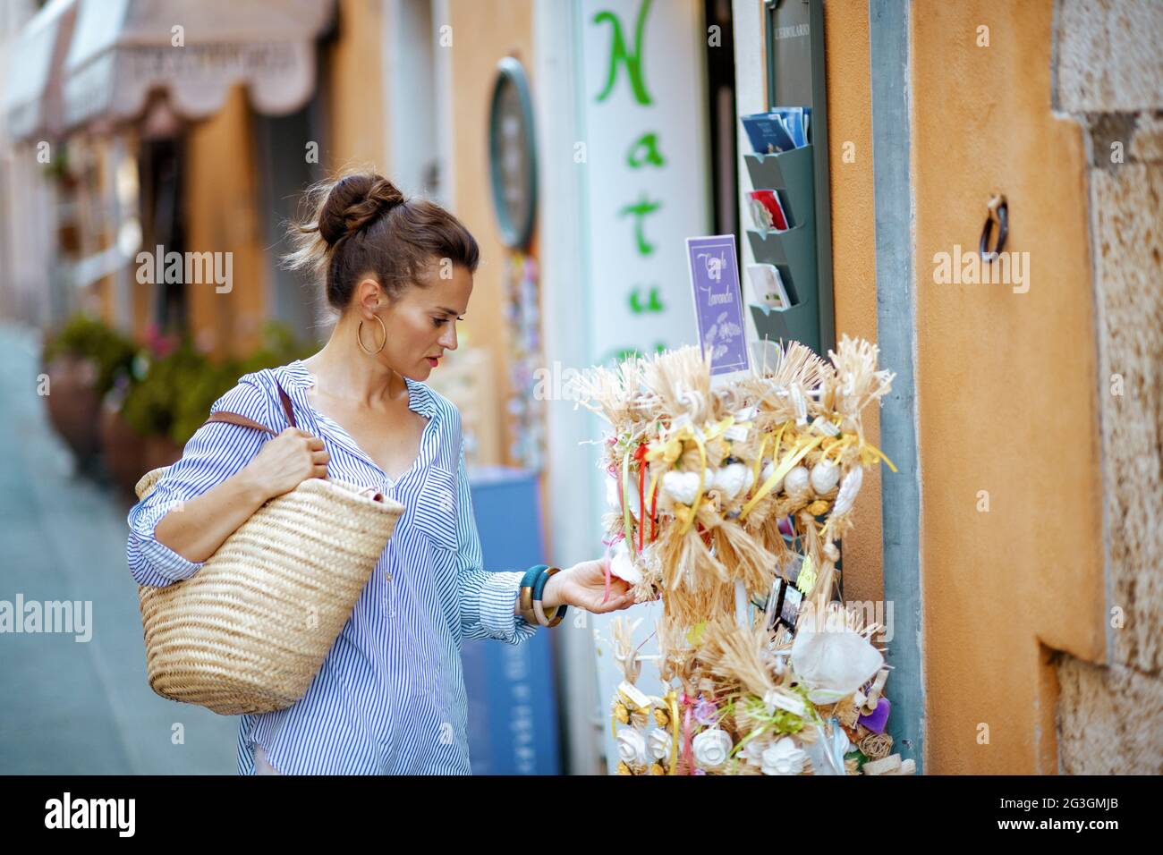 Pienza, Italie - août 10, 2019: Femme élégante avec sac de paille en Toscane, Italie. Banque D'Images