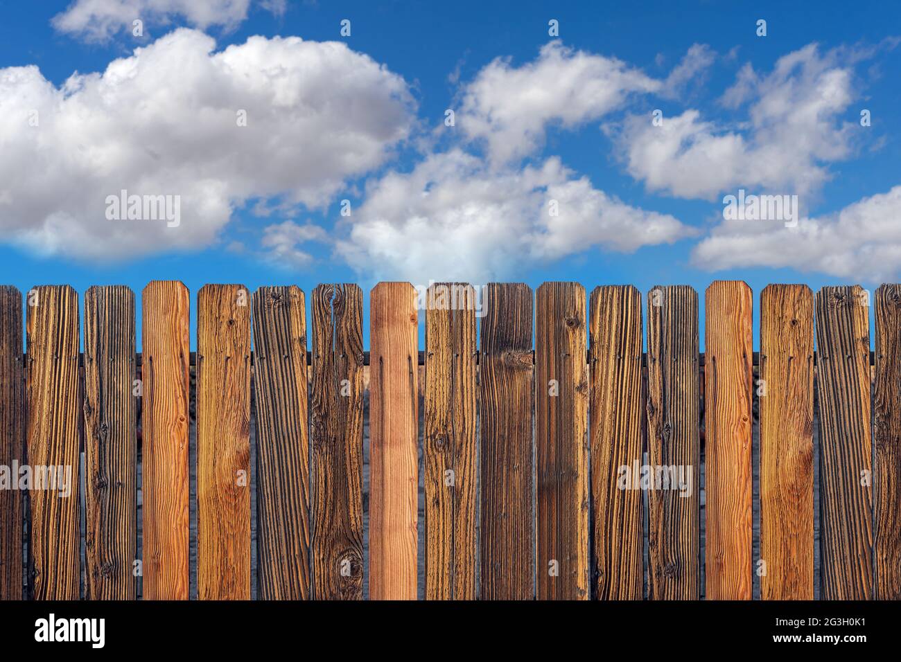 Clôture en bois vieilli avec ciel bleu ciel nuageux Banque D'Images