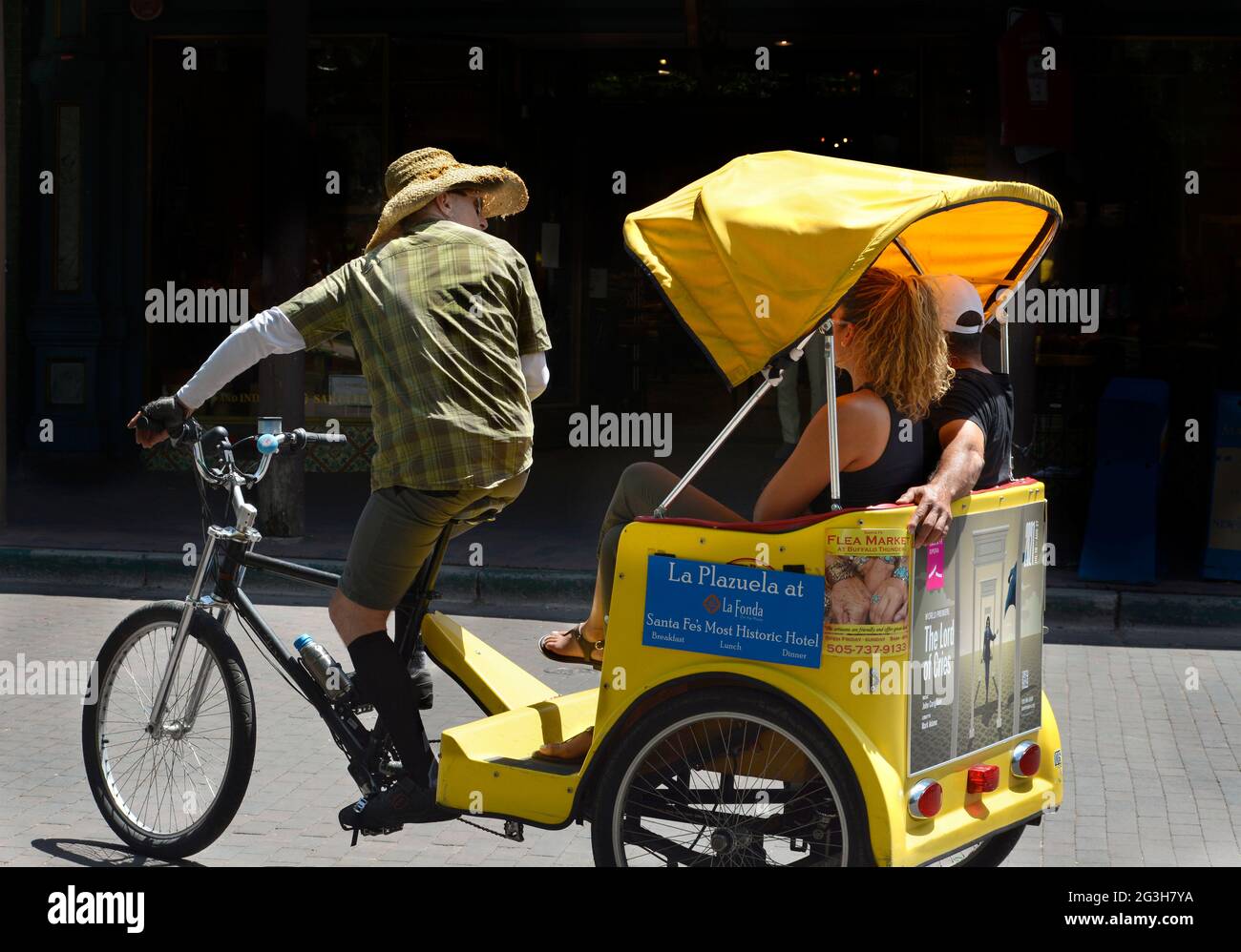 Un couple en visite à Santa Fe, Nouveau-Mexique, profitez des sites dans un pédicab. Banque D'Images