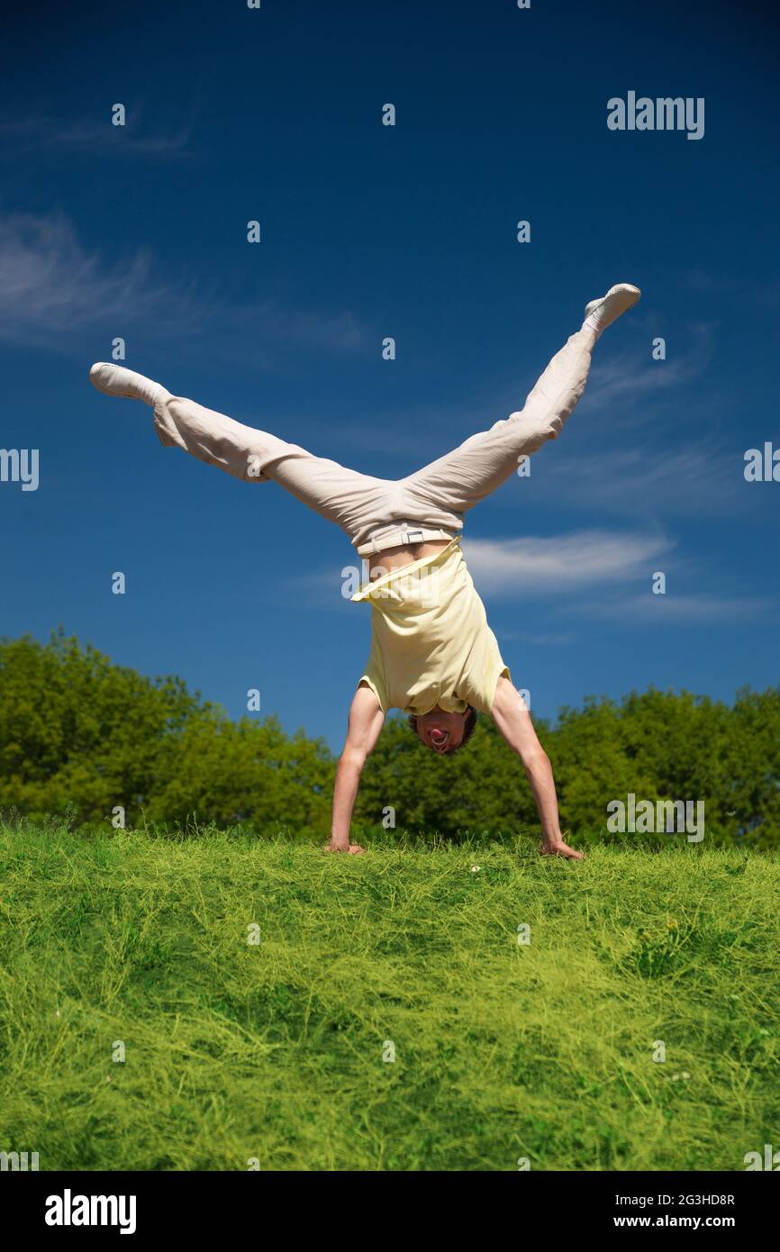 Jeune homme jump sur hill in park Banque D'Images
