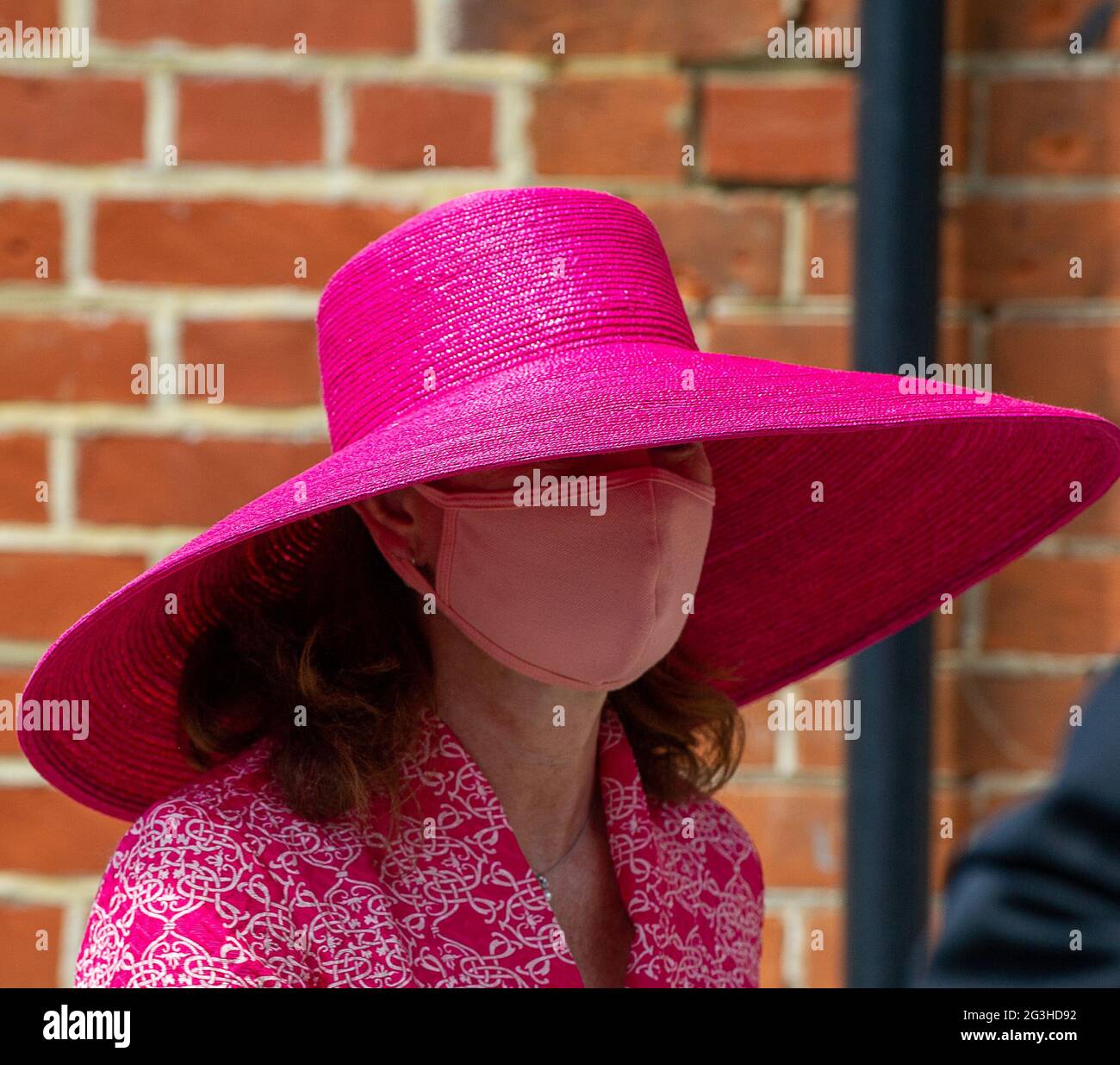 Ascot, Berkshire, Royaume-Uni. 16 juin 2021. Une dame porte un chapeau rose à large bord et un masque facial. Racegoers arrivant le deuxième jour de Royal Ascot alors que la canicule continue. En raison des restrictions actuelles de Covid-19, les pilotes doivent fournir la preuve d'un test négatif de Covid-19 avant d'être autorisés à accéder à l'hippodrome d'Ascot. Crédit : Maureen McLean/Alay Banque D'Images