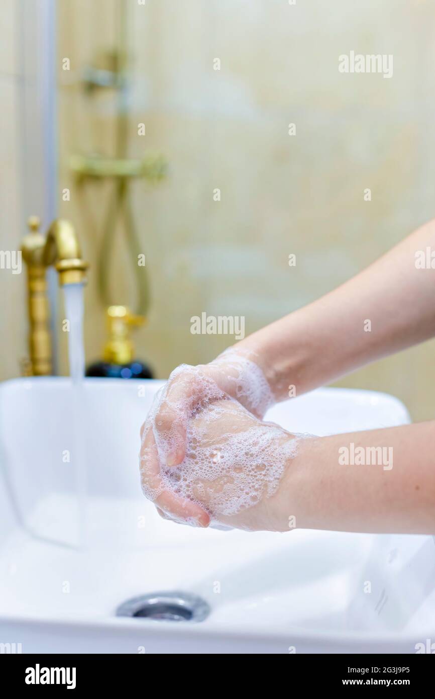 Femme se lavant et se désinfectant les mains avec du savon et de l'eau chaude dans le cadre des protocoles de prévention et de protection du coronavirus; cesser de propager l'hygie covid-19 Banque D'Images