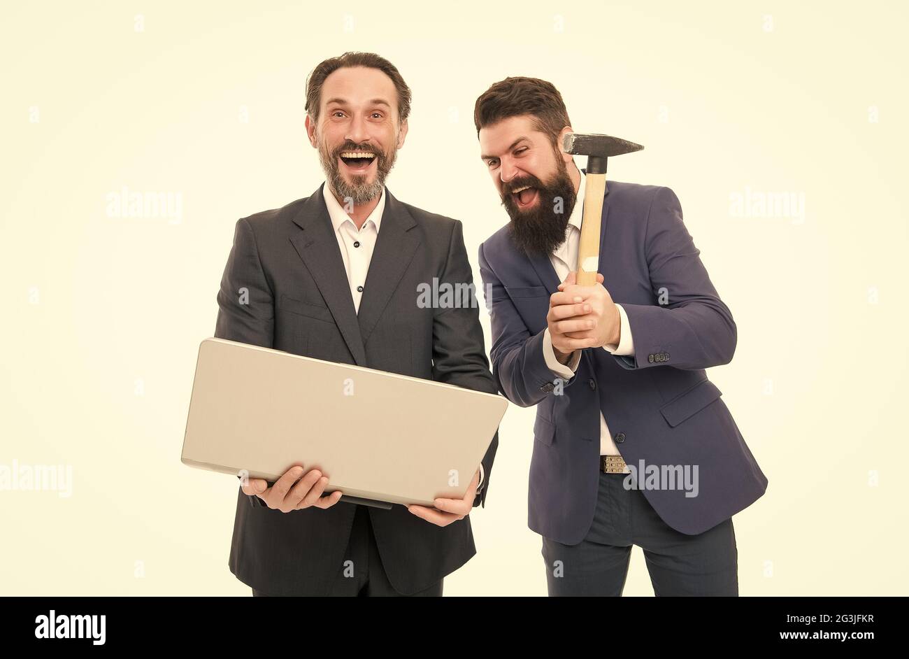 Il vous suffit parfois de laisser la vapeur s'éteindre. Des responsables fous ont frappé l'ordinateur portable avec un marteau. Des hommes d'affaires brutaux avec un look fou. Hommes barbus d'humeur folle. Fou Banque D'Images