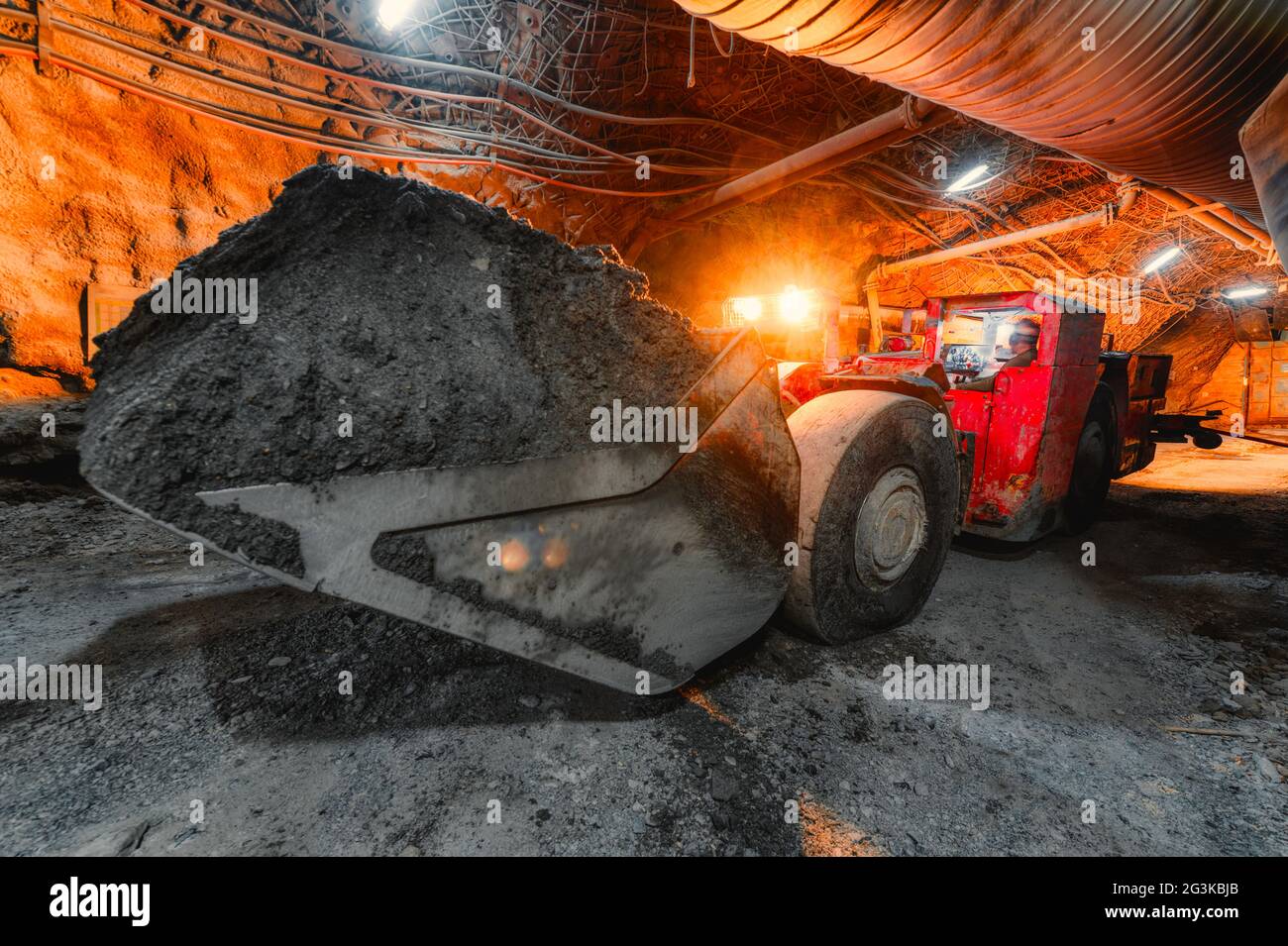 Une machine de chargement souterraine transporte un godet plein de minerai. Équipement compact spécial pour les travaux souterrains Banque D'Images