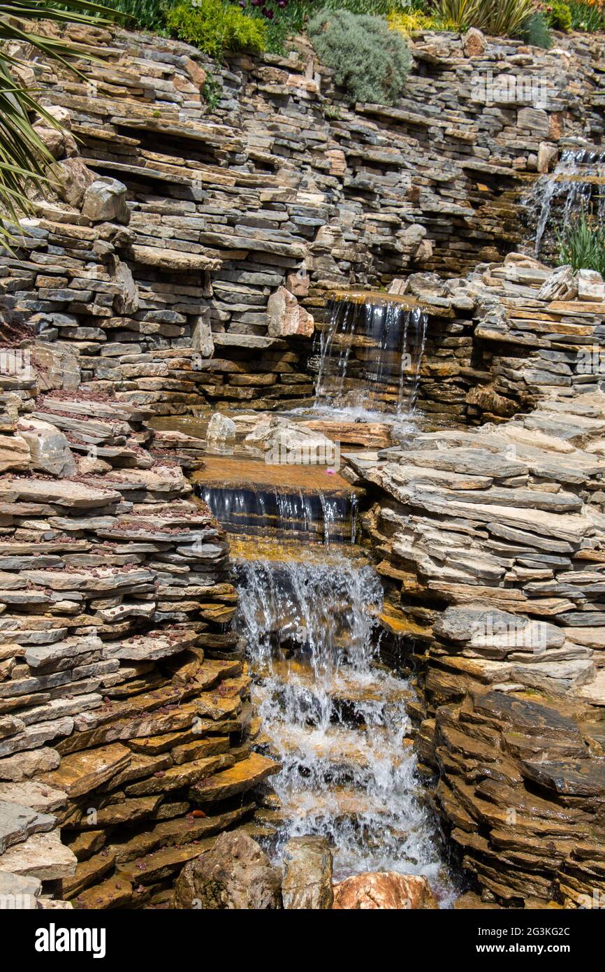 Plan vertical d'une petite cascade rocheuse qui coule dans une petite piscine Banque D'Images