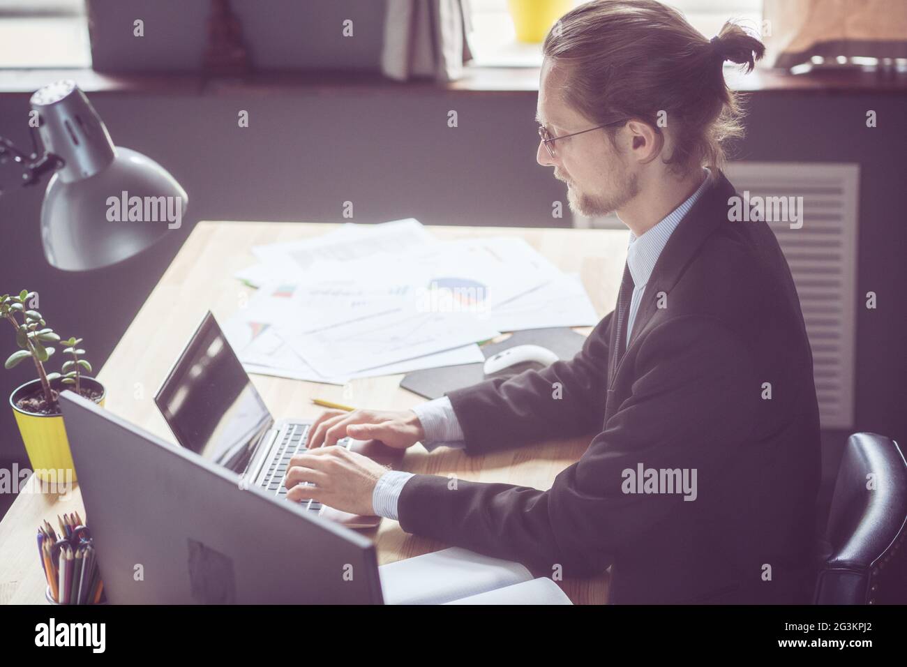 Freelancer en costume noir travailler avec ordinateur portable. Banque D'Images