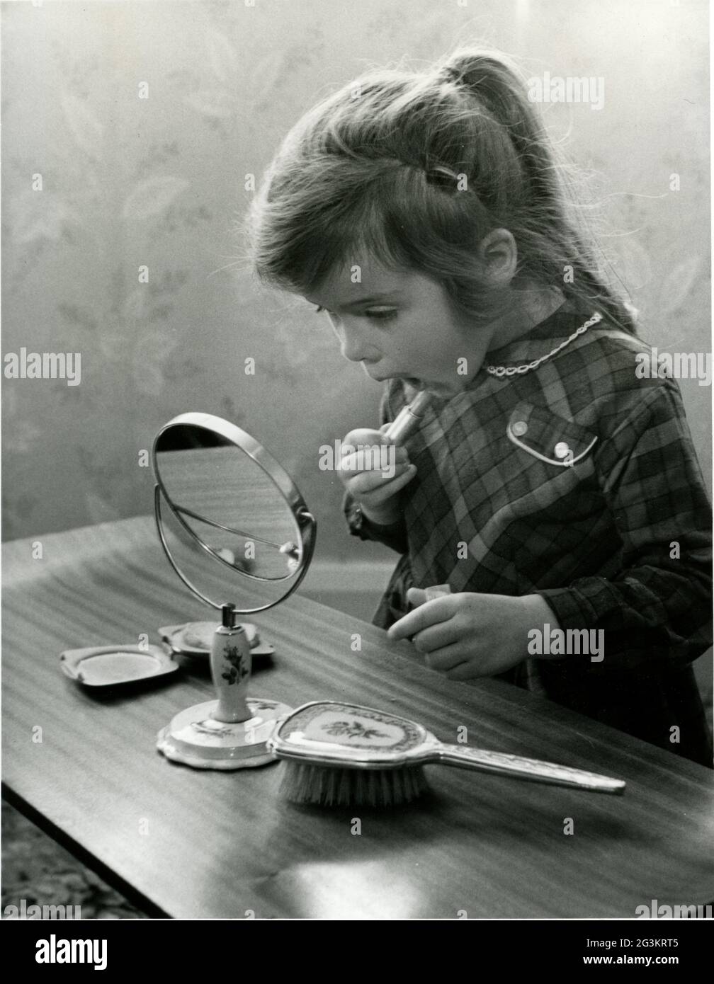 Cosmétiques, petite fille appliquant le rouge à lèvres, 22.4.1963, DROITS-SUPPLÉMENTAIRES-AUTORISATION-INFO-NON-DISPONIBLE Banque D'Images
