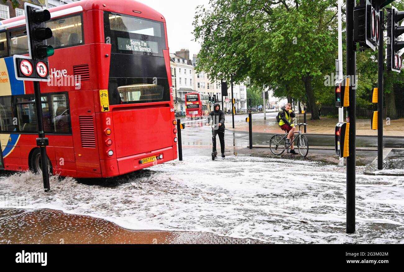 Brighton Royaume-Uni 17 juin 2021 - UN cycliste et un scooter montre qu'un bus traverse des eaux de crue sur les routes de Valley Gardens à Brighton après une nuit de fortes pluies et de tempêtes de tonnerre dans le Sud-est : Credit Simon Dack / Alay Live News Banque D'Images