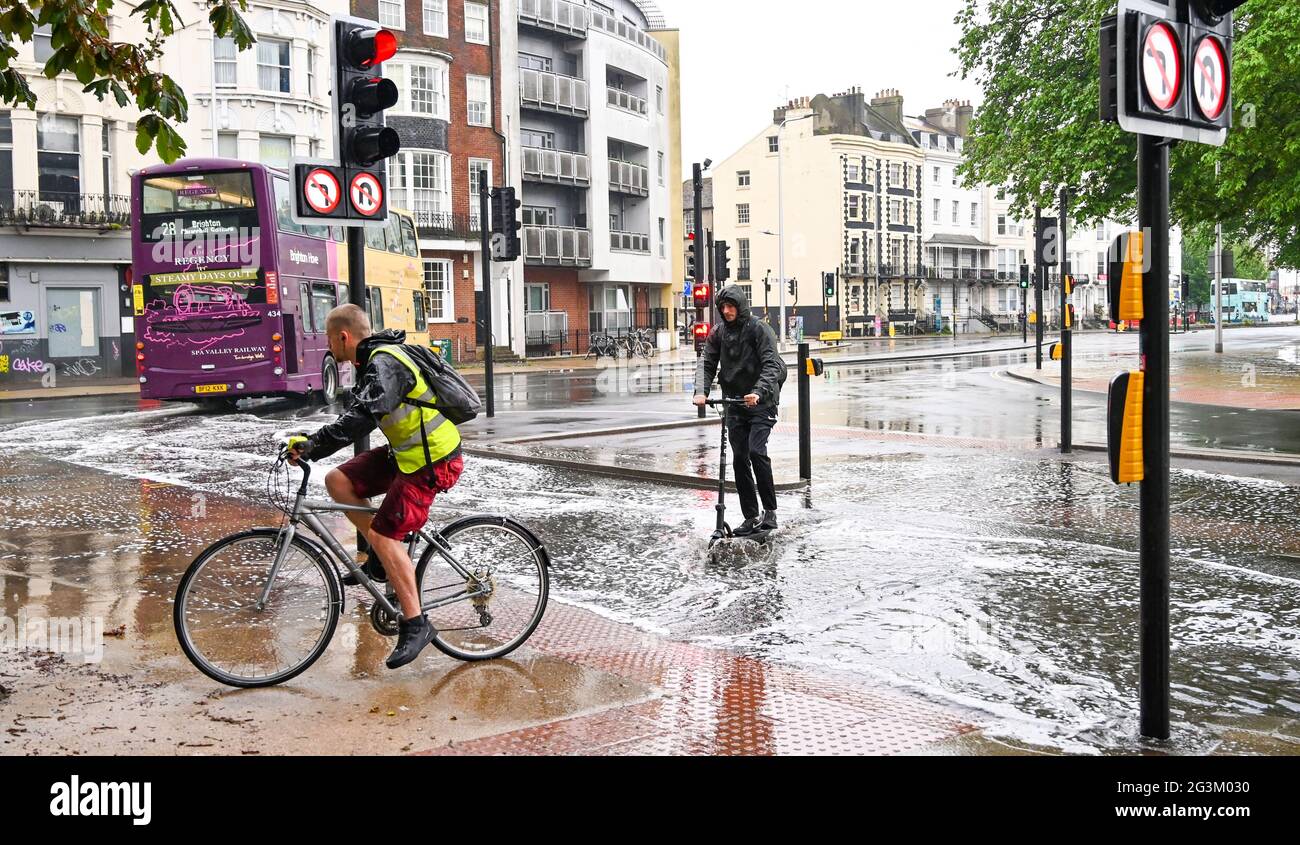 Brighton Royaume-Uni 17 juin 2021 - UN cycliste et un scooter pilote négocient l'eau de crue sur les routes de Valley Gardens à Brighton après une nuit de fortes pluies et de tempêtes de tonnerre dans le Sud-est : Credit Simon Dack / Alay Live News Banque D'Images