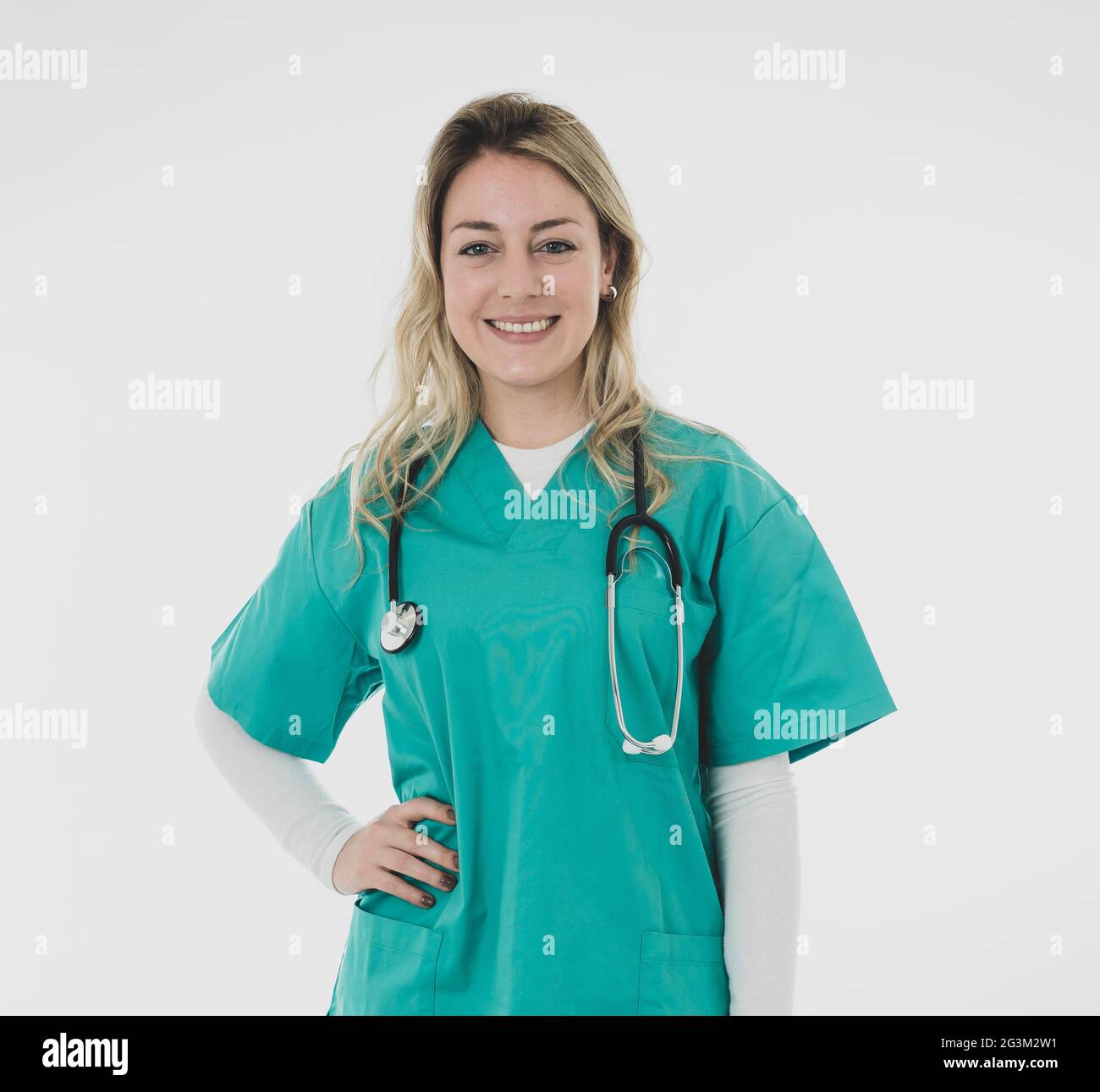 Young beautiful smiling medical professional femme médecin ou infirmière holding stethoscope en vert frotte contre fond blanc avec copie espace dans il Banque D'Images