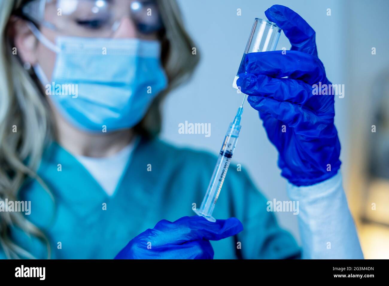 Médecin, infirmière, scientifique main dans des gants bleus tenant la grippe, la rougeole, le coronavirus, la covid-19 maladie de vaccin se préparant pour l'enfant, le bébé, l'adulte, l'homme et le wom Banque D'Images