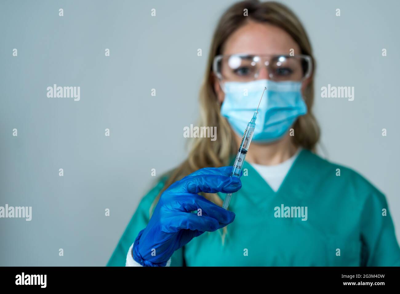 Médecin, infirmière, scientifique main dans des gants bleus tenant la grippe, la rougeole, le coronavirus, la covid-19 maladie de vaccin se préparant pour l'enfant, le bébé, l'adulte, l'homme et le wom Banque D'Images