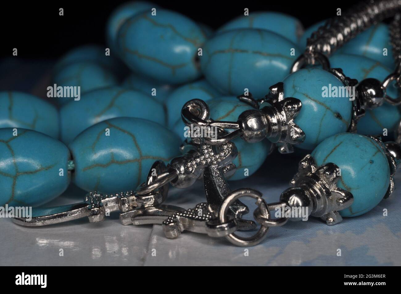 Gros plan de bracelets de perles turquoise sur une surface brillante Banque D'Images