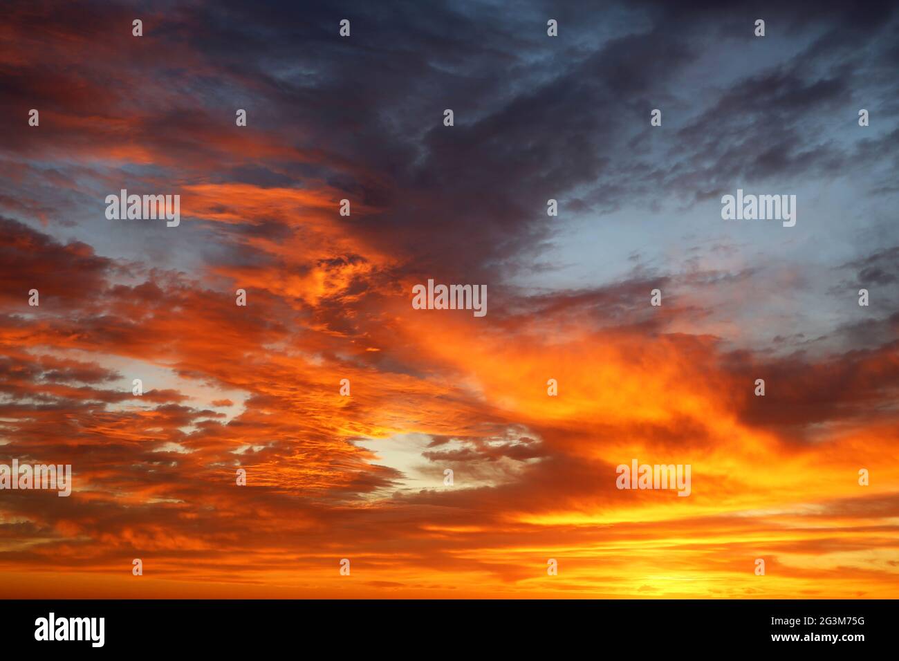 Coucher de soleil sur un ciel spectaculaire et coloré avec des nuages rouges et orange. Paysage pittoresque pour un arrière-plan aux couleurs infernales Banque D'Images