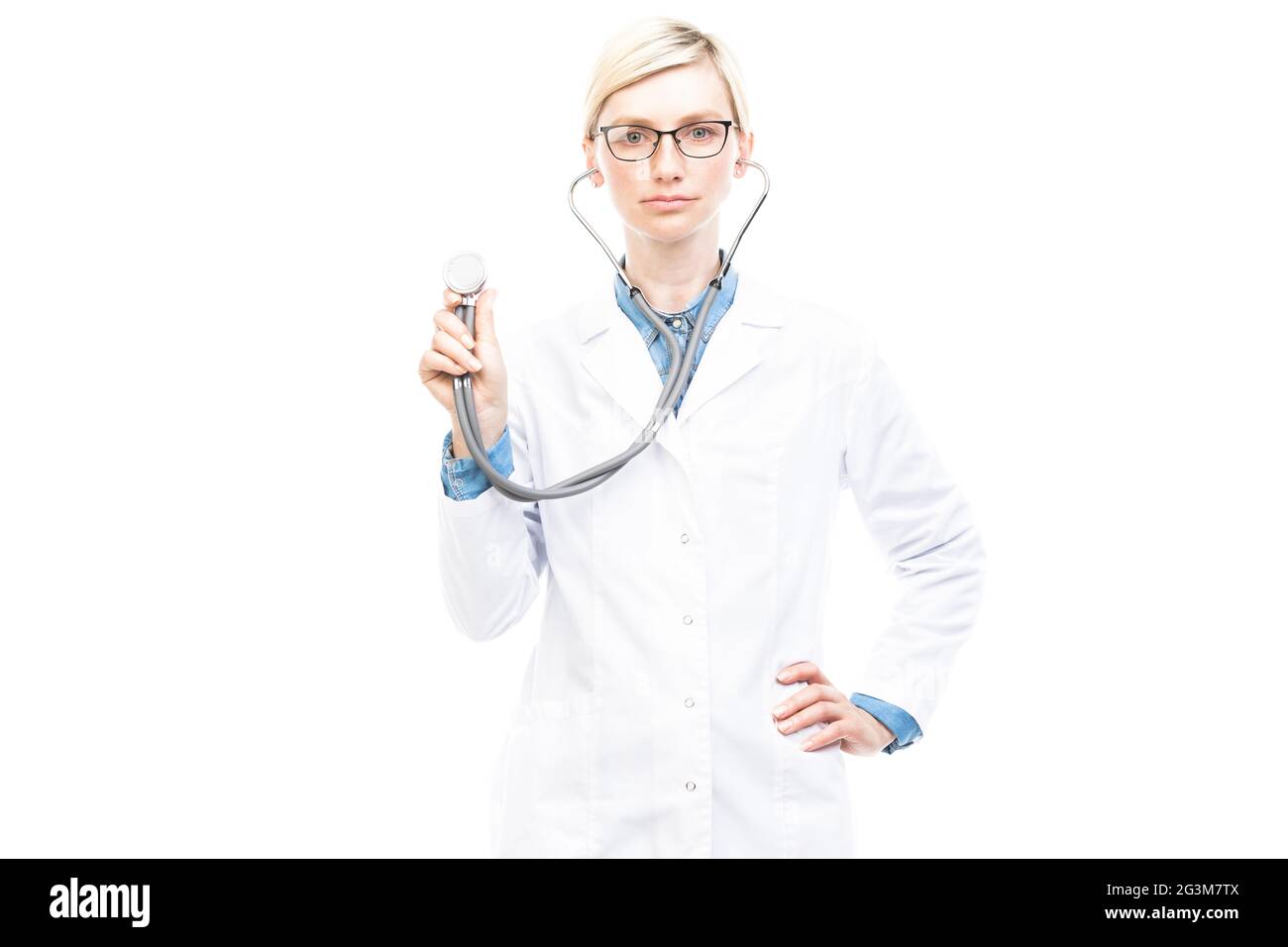 Portrait horizontal moyen d'un beau médecin caucasien portant un manteau blanc et des lunettes posé sur l'appareil photo avec stéthoscope Banque D'Images
