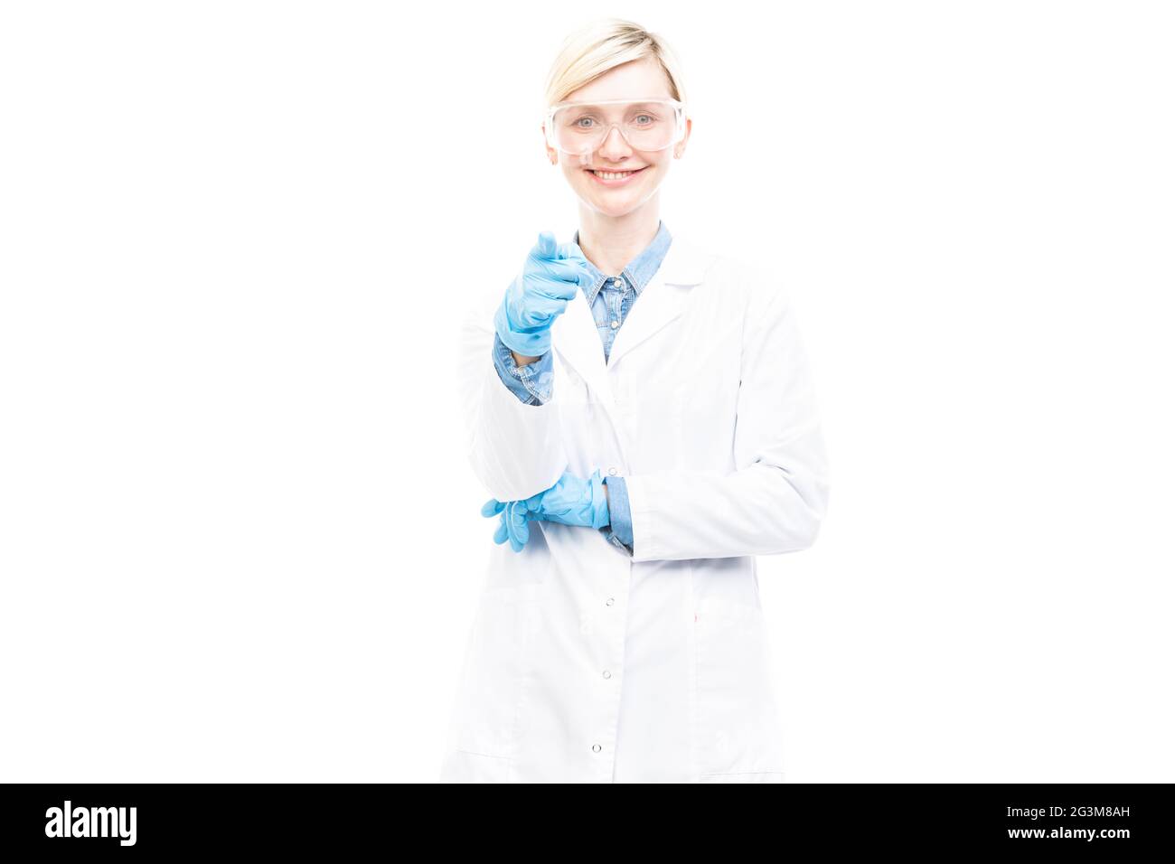 Portrait horizontal moyen réussi de beau médecin caucasien portant un manteau blanc, des gants en latex et des lunettes pointant le doigt vers la caméra Banque D'Images