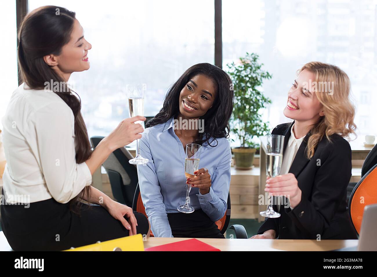 Équipe de femmes d'affaires ayant du champagne au bureau Banque D'Images