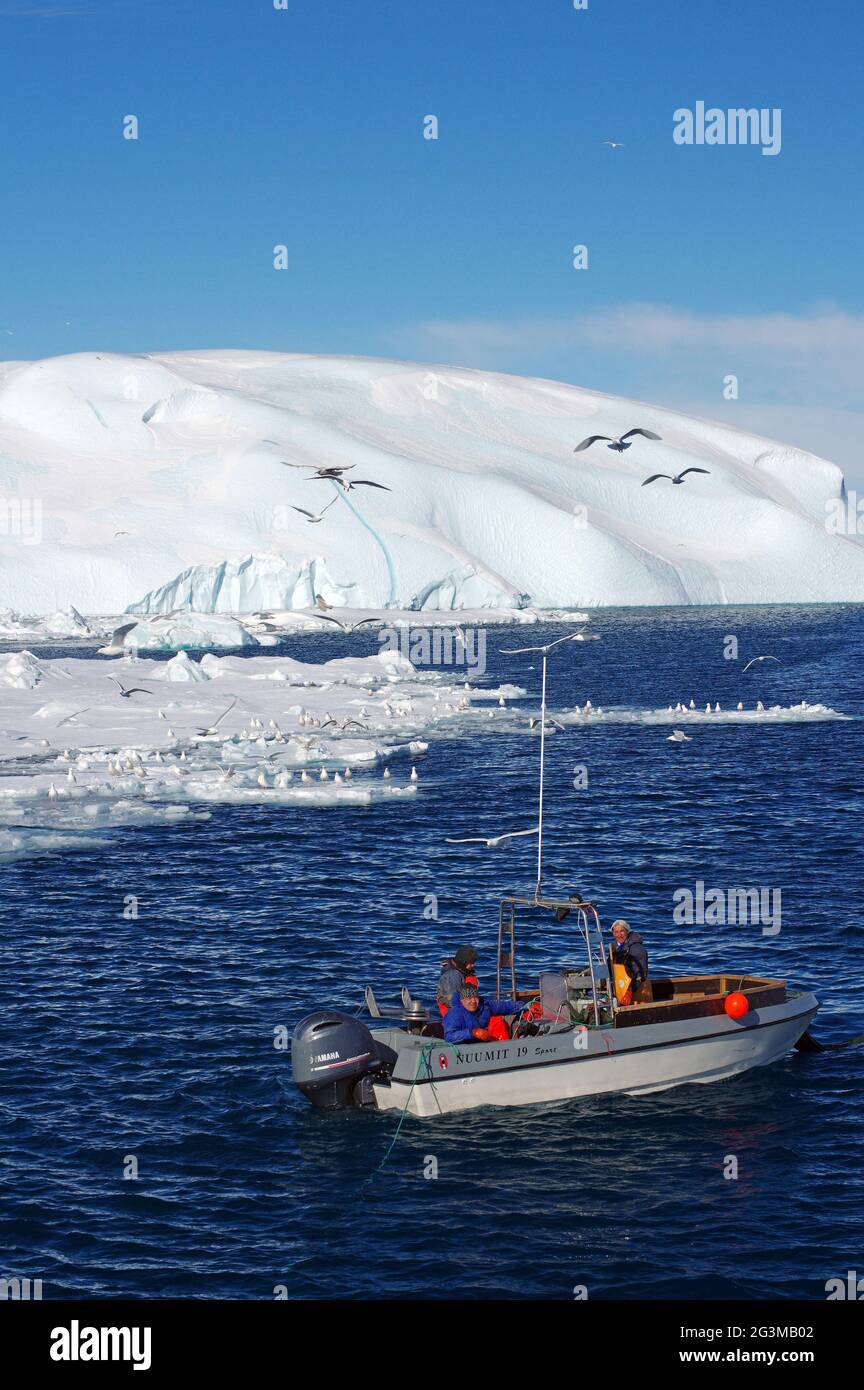 Petit bateau de pêche en face d'Icebergs Banque D'Images
