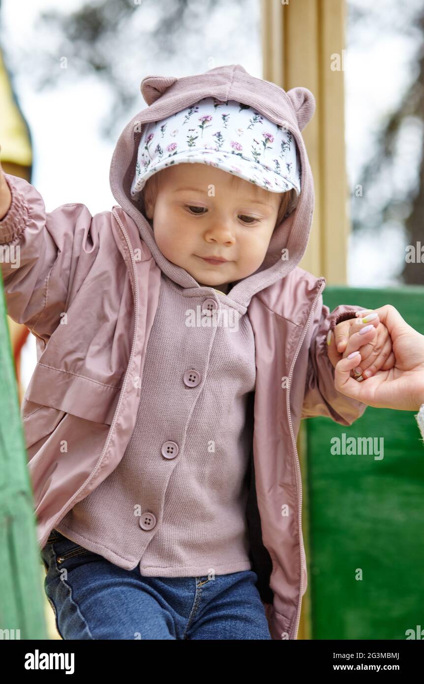 Maman et fille sur l'aire de jeux extérieure. Activité saine pour les enfants. La petite fille et la mère ont un bon moment Banque D'Images