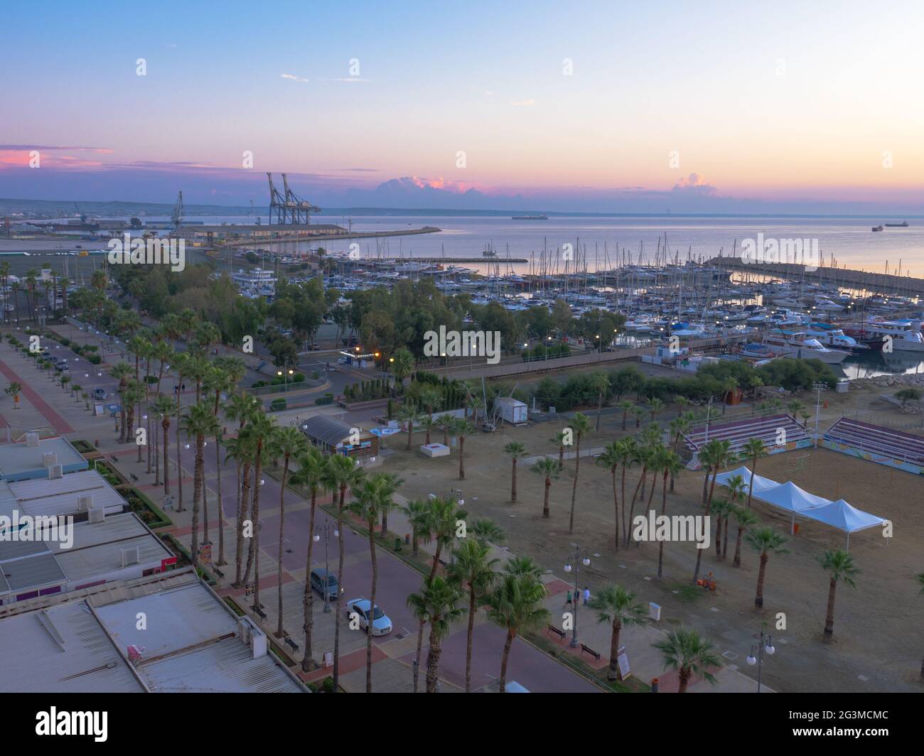 Vue aérienne du haut surplombant la belle matinée à la promenade des palmiers de Finikoudes, jetée avec yachts près de la mer Méditerranée, et terrain de volley-ball. Banque D'Images