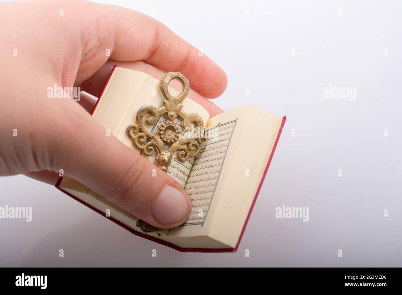 Main tenant la clé et le Livre Saint islamique Coran Banque D'Images