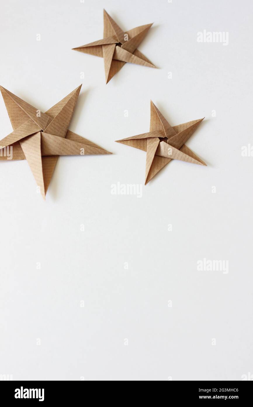 Fond blanc de Noël et du nouvel an avec les étoiles Kraft Origami. Maquette des fêtes. Banque D'Images